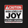 A black t-shirt featuring a printed graphic of a warning sign that reads 'CAUTION: HIGH LEVELS OF JOY EXTREMELY CONTAGIOUS ACTS 13:52' in red, white, and black.